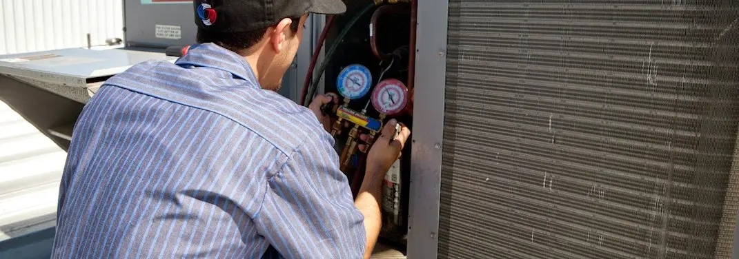 HVAC technician servicing a condenser unit in Estero