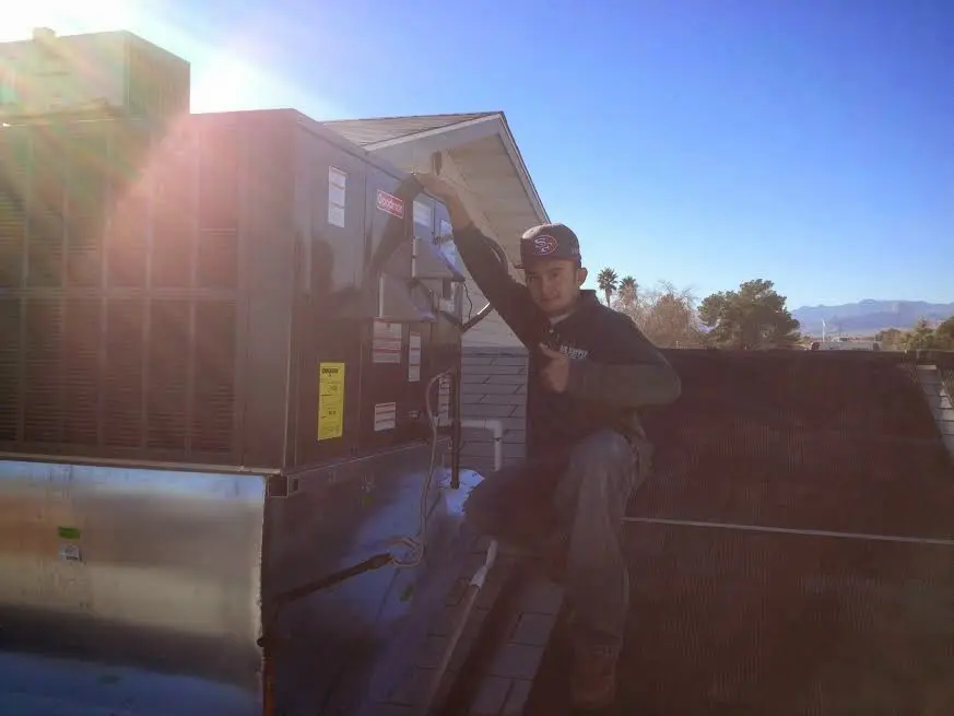 HVAC technician performing HVAC Inspection on a rooftop unit in Estero